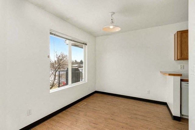 an empty living room with a large window and wood floors