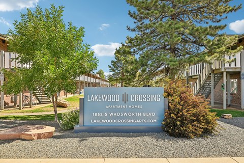 A sign for Lakewood Crossing Apartment Homes stands in front of a building.