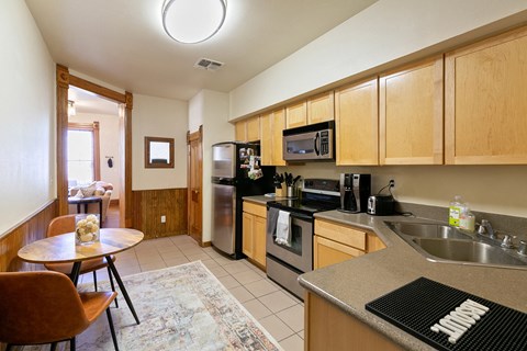 full kitchen with stainless steel appliances and wooden cabinets and a dining room table