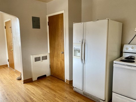 A white refrigerator sits next to a white stove in a kitchen.