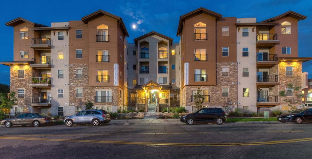 Apartment building with cars parked in front at dusk.at Peregrine Place Apartments, Colorado, 80246