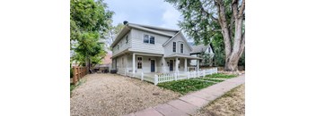 A house with a white picket fence in front.