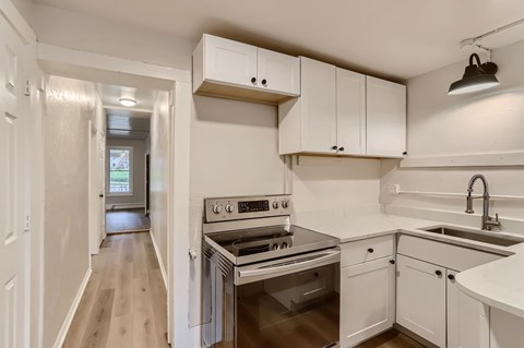 A kitchen with white cabinets and a stainless steel oven.