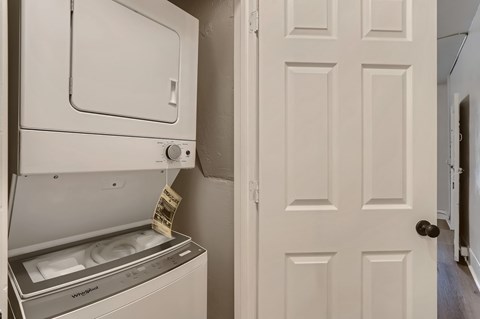 A washing machine is placed next to a white door.