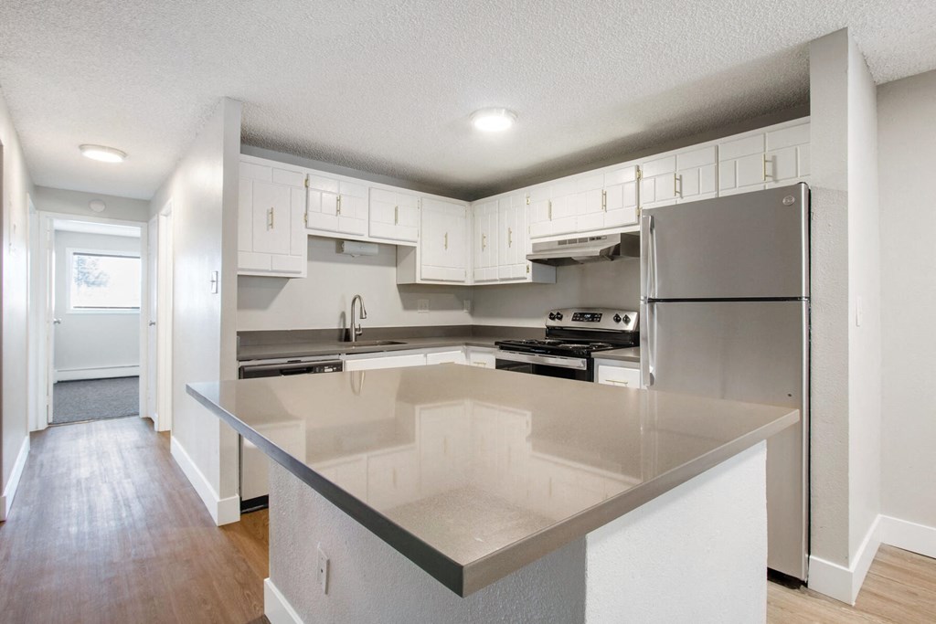 an empty kitchen with white cabinets and stainless steel appliances