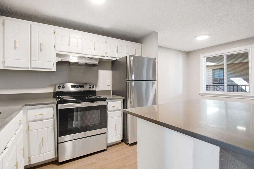 a kitchen with stainless steel appliances and white cabinets