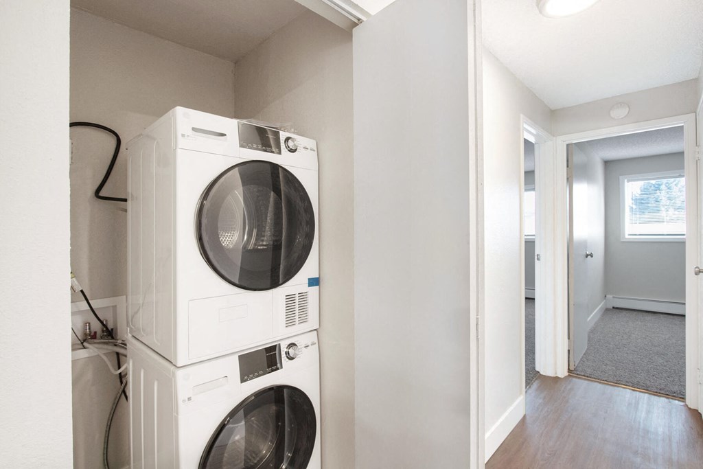 a white washer and dryer in a laundry room with a door open