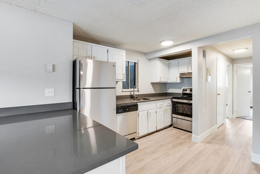 a kitchen with white cabinets and a stainless steel refrigerator
