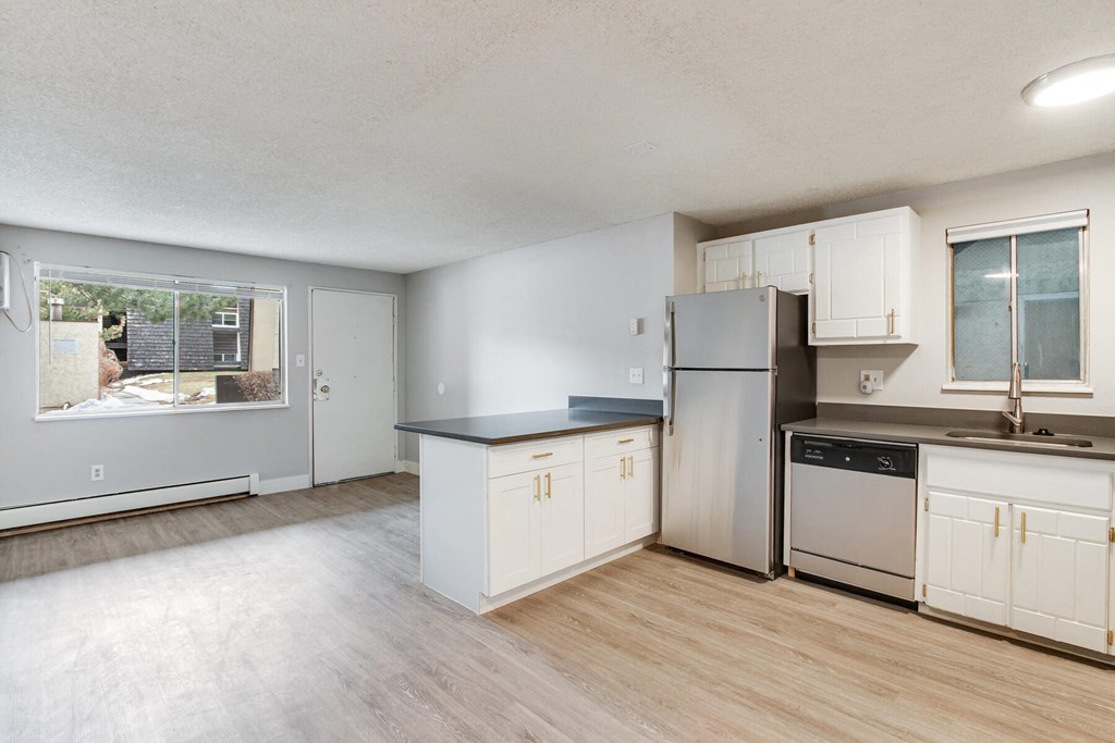 an empty kitchen with white cabinets and stainless steel appliances