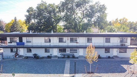 A white building with a pool in front of it.
