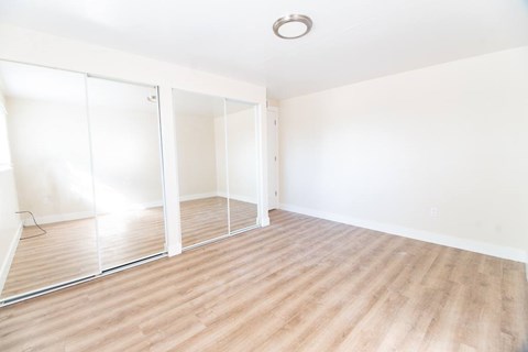A room with a sliding door and wooden flooring.