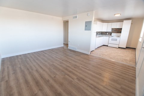 A room with wooden flooring and white walls.