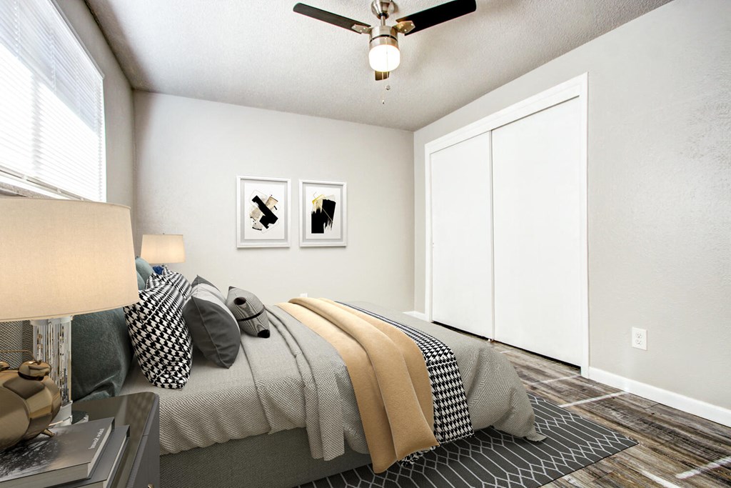a bedroom with a ceiling fan and two windows
