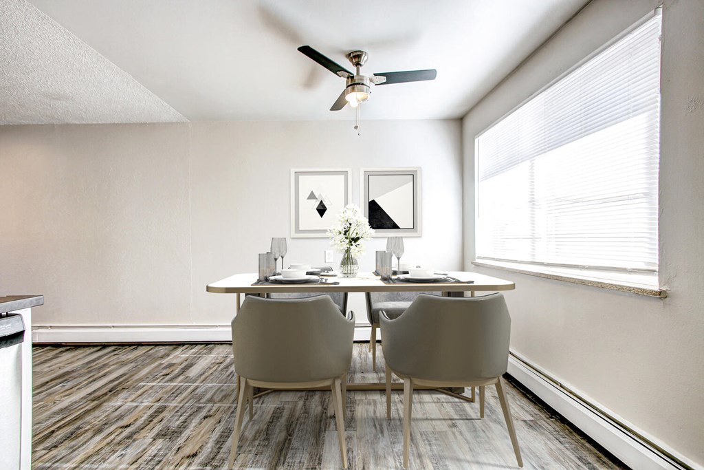 a dining room with white walls and a ceiling fan