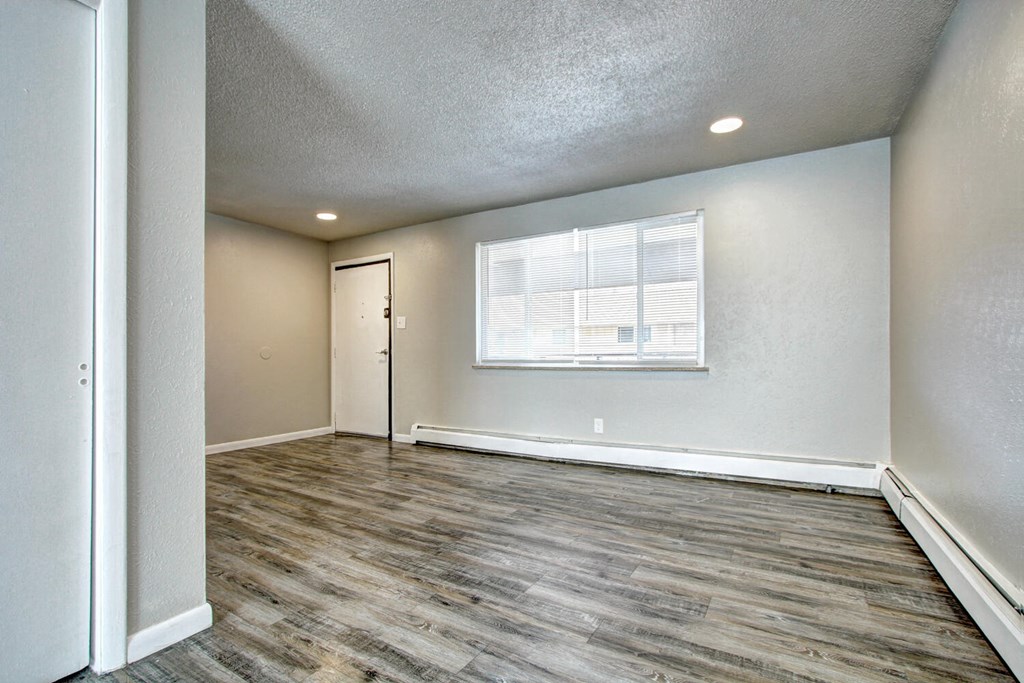 a bedroom with hardwood flooring and a large window