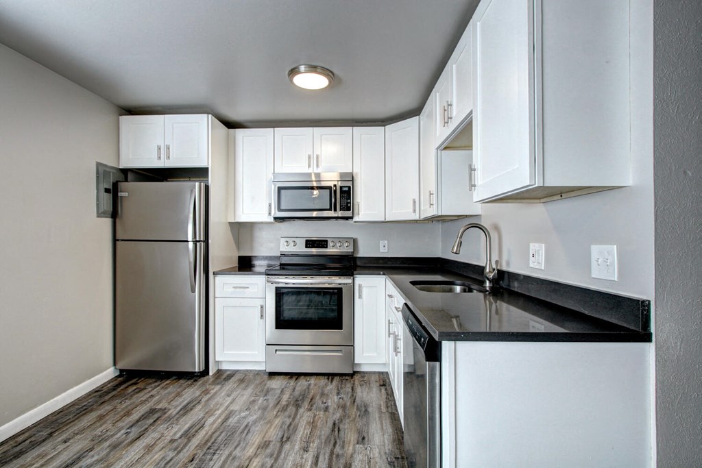a kitchen with white cabinets and stainless steel appliances