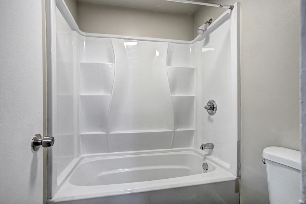 a bathroom with a white tub and a white toilet