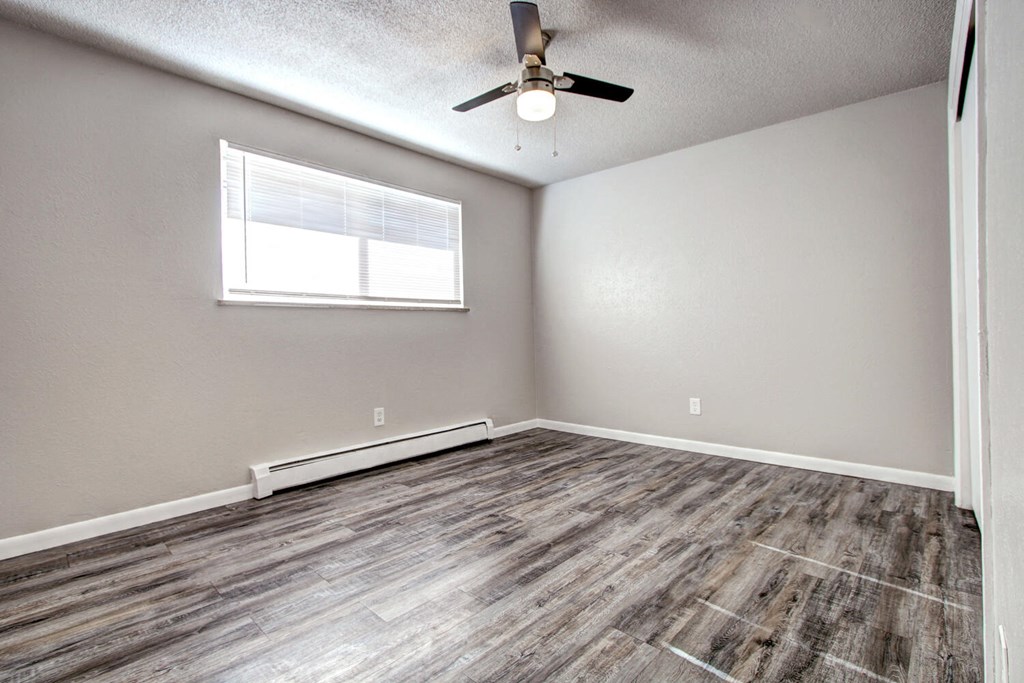 an empty room with a ceiling fan and a window