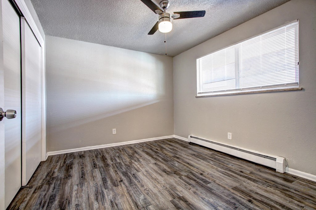 an empty room with a ceiling fan and a window