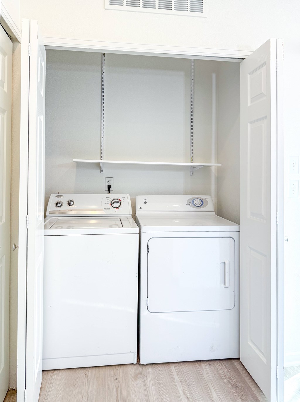 A small laundry room with a washer and dryer.