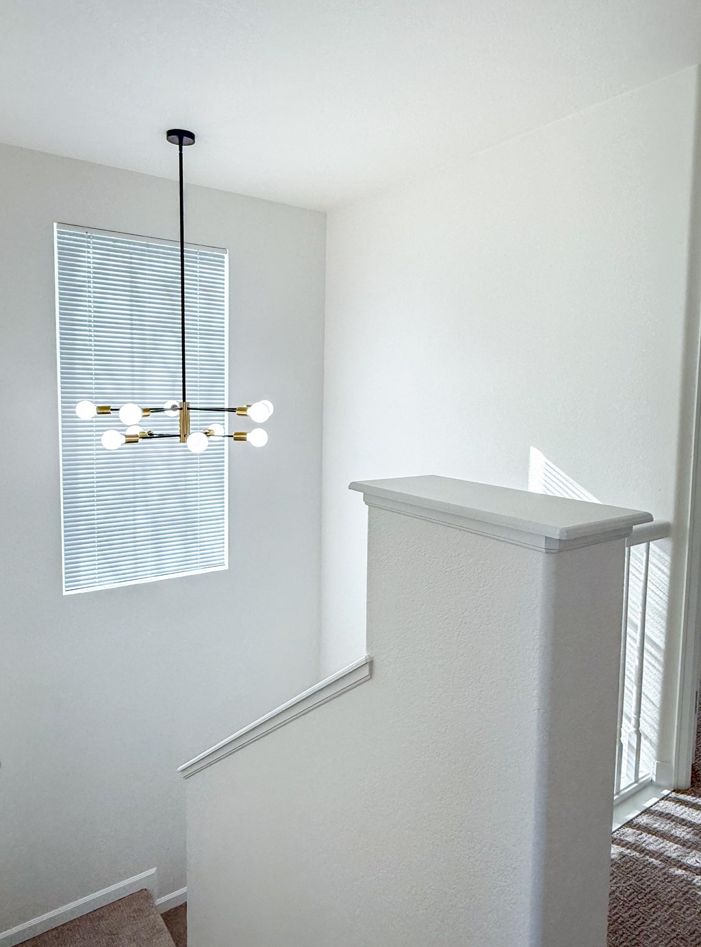 A white staircase with a light hanging from the ceiling.