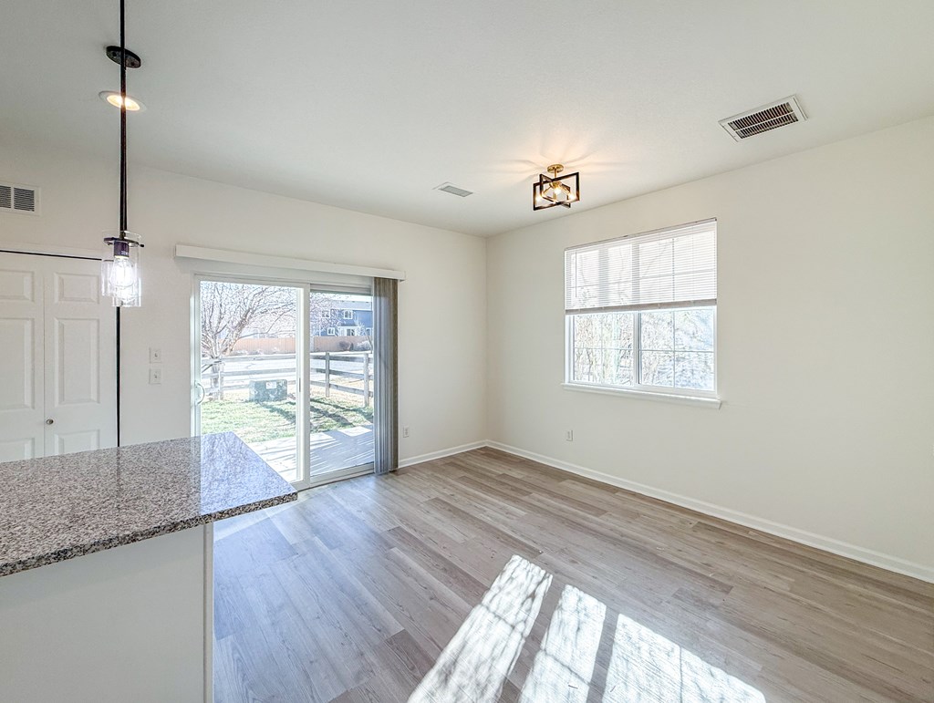 A sunny day in a spacious room with a marble countertop and a window.