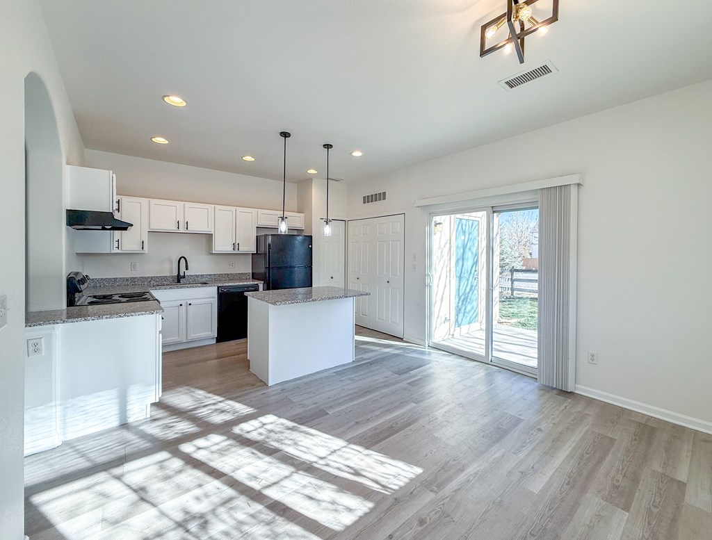 A kitchen with white cabinets and a large island.