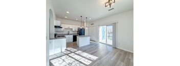 A kitchen with white cabinets and a large island.