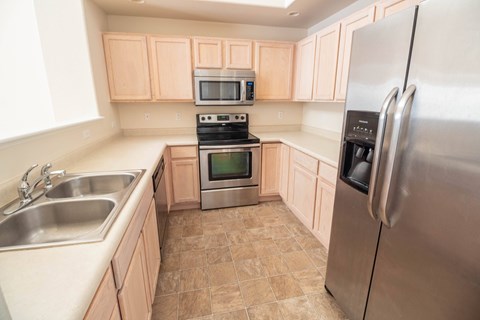 A kitchen with a stainless steel refrigerator, a stainless steel oven, and a stainless steel microwave.