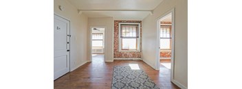 a living room with two windows and a rug