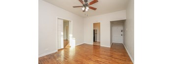 a bedroom with hardwood floors and a ceiling fan