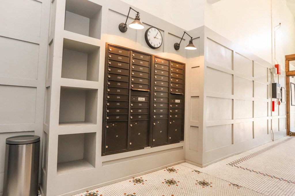 a room with a bunch of mailboxes and a clock on the wall
