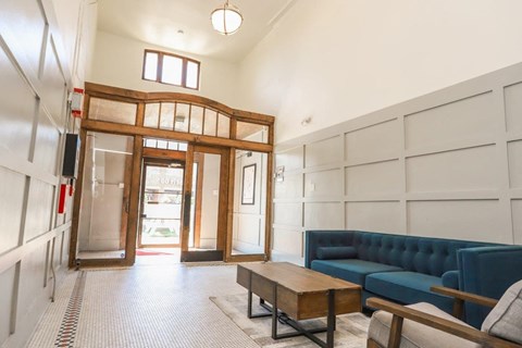 a lobby with a blue couch and a wooden coffee table