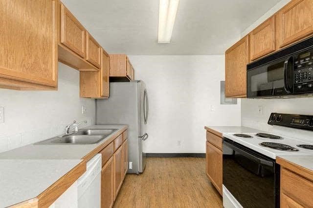 a kitchen with a stove refrigerator and sink