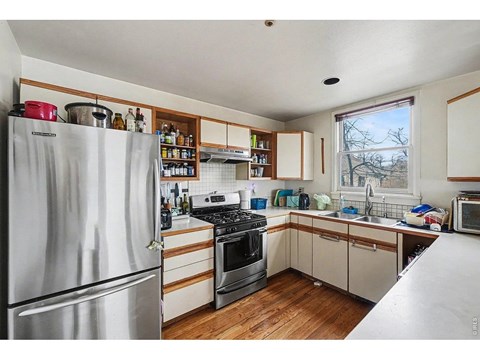 A kitchen with a refrigerator, oven, and microwave.