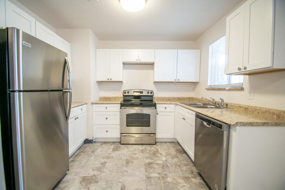 a kitchen with stainless steel appliances and white cabinets