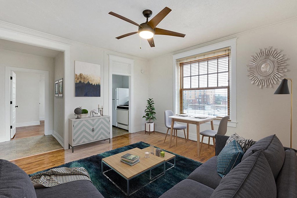 a living room with a couch and a table in front of a window