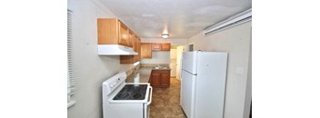 A kitchen with white appliances and wooden cabinets.