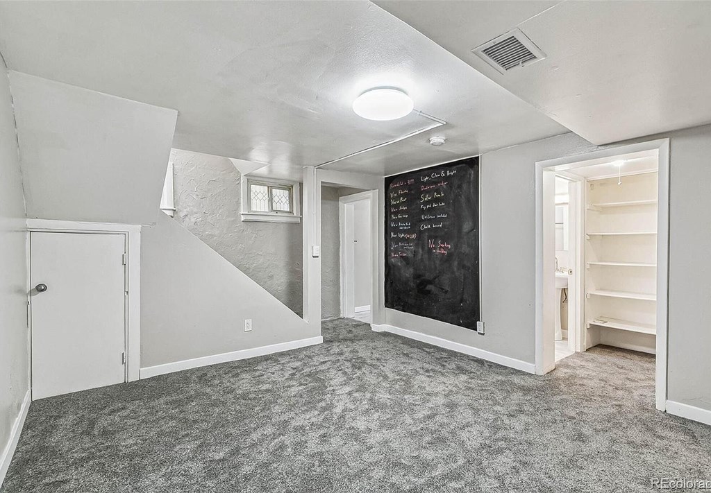 A room with a chalkboard on the wall and a carpet on the floor.