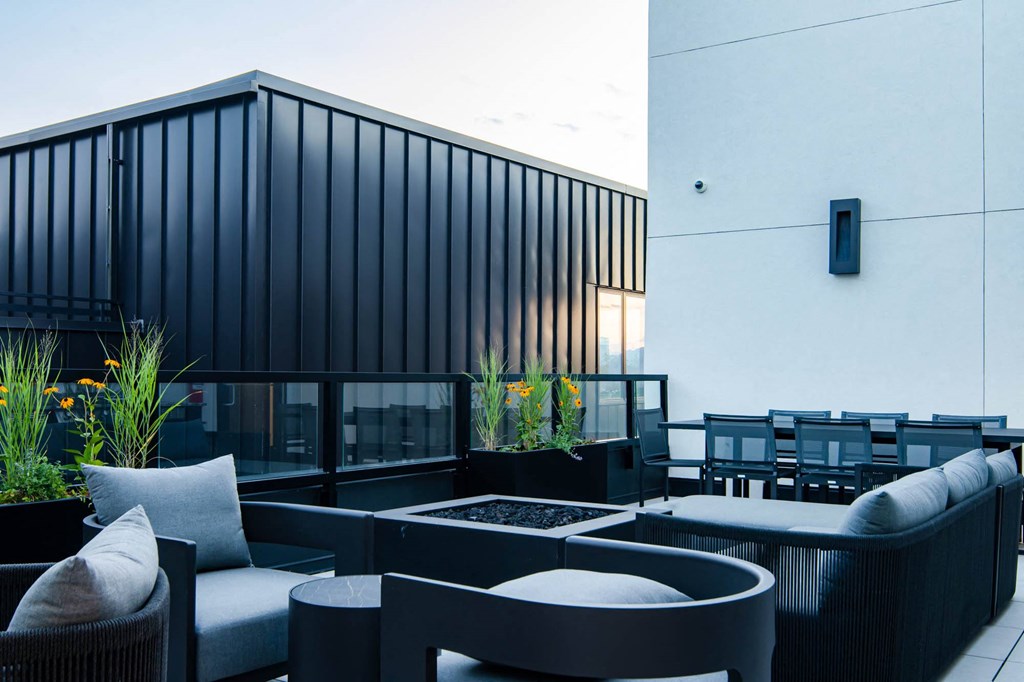 a terrace with couches and chairs and a fire pit