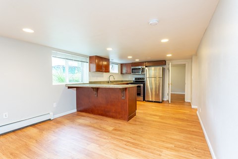 an empty kitchen with a wooden floor and a counter top