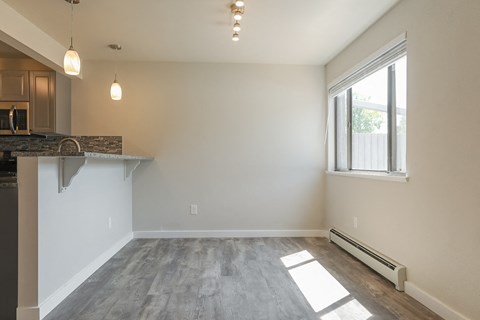 A spacious living room with a fireplace and a window.