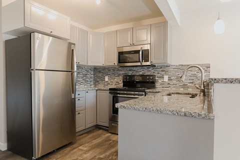 A modern kitchen with a stainless steel refrigerator and microwave.