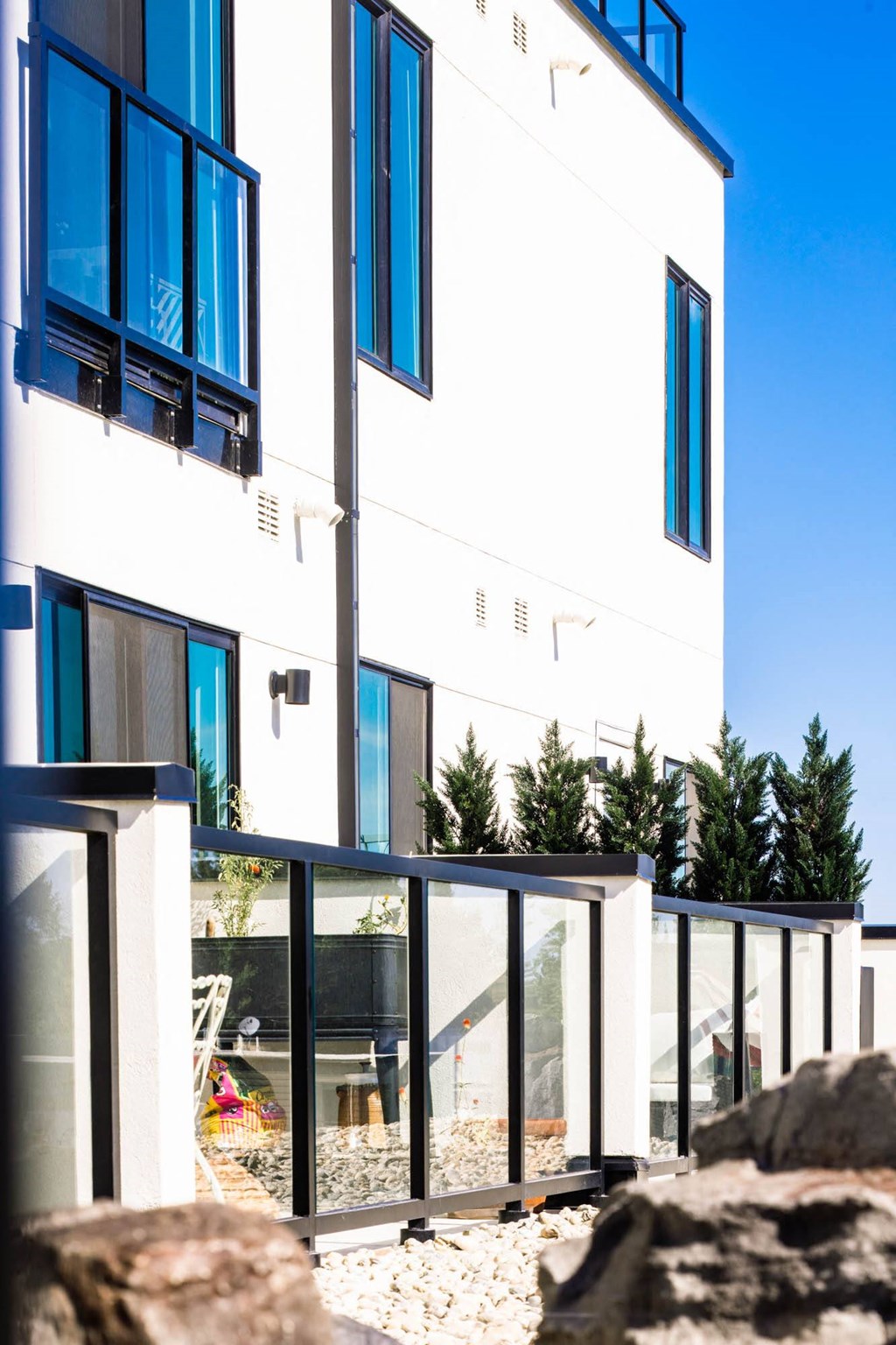 a large white house with blue windows and a fence