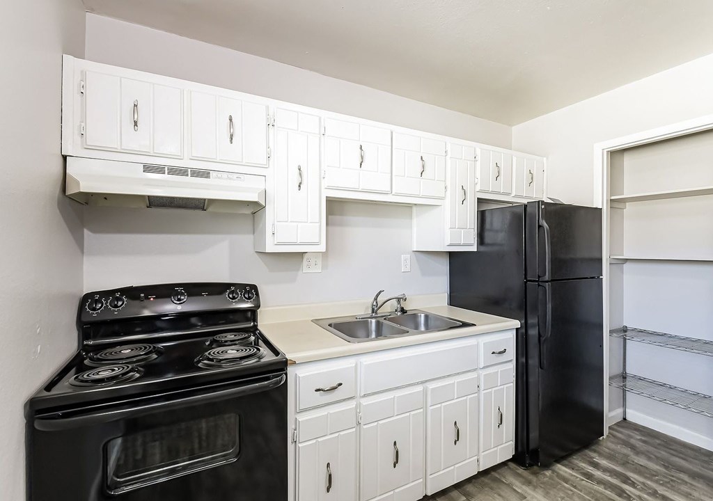 A black stove and oven in a kitchen with white cabinets.