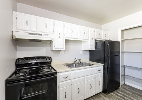 A black stove and oven in a kitchen with white cabinets.