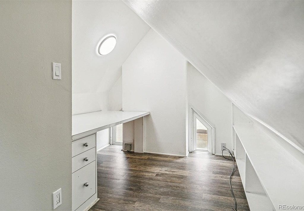 A room with a desk and drawers in it.
