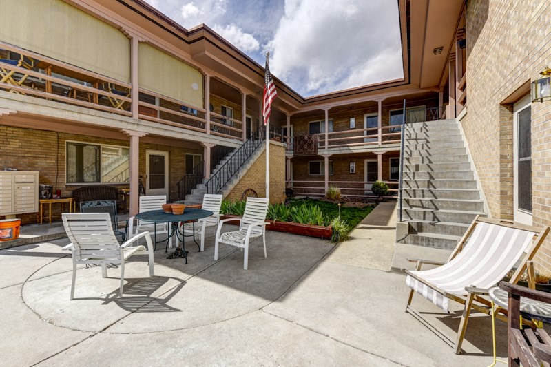 a patio with chairs and an flag in front of a building