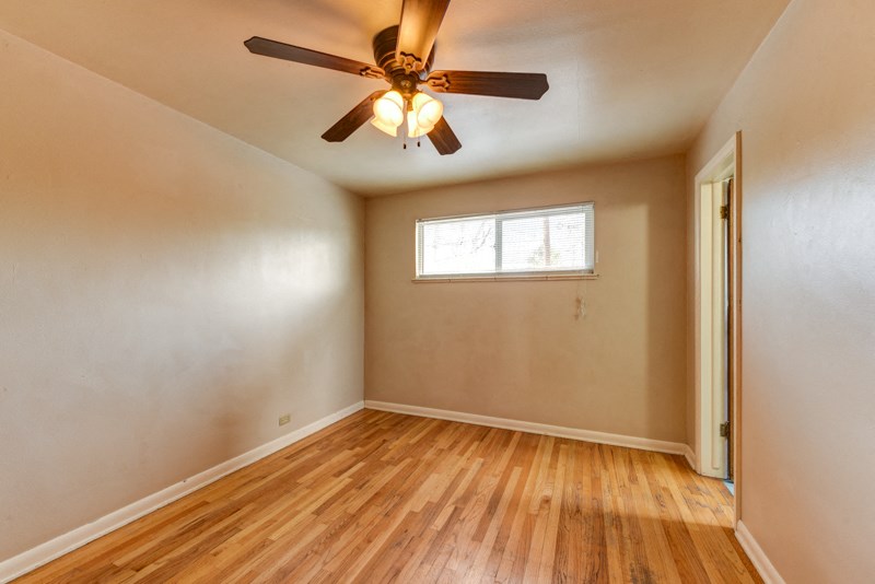 the living room of an empty house with a ceiling fan