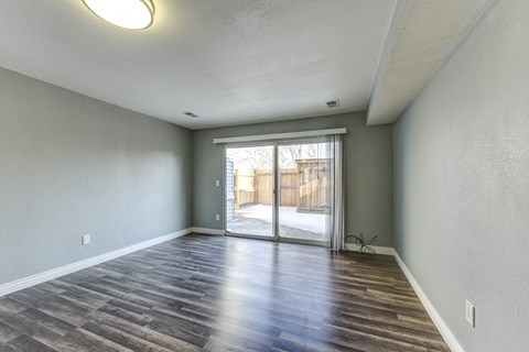 the spacious living room with sliding glass door to the patio